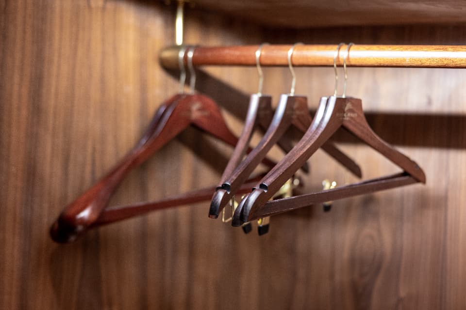Cintres en bois alignés sur une tringle